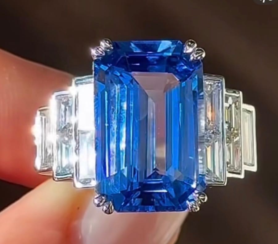 Emerald-cut blue sapphire ring with step-set baguette shoulders