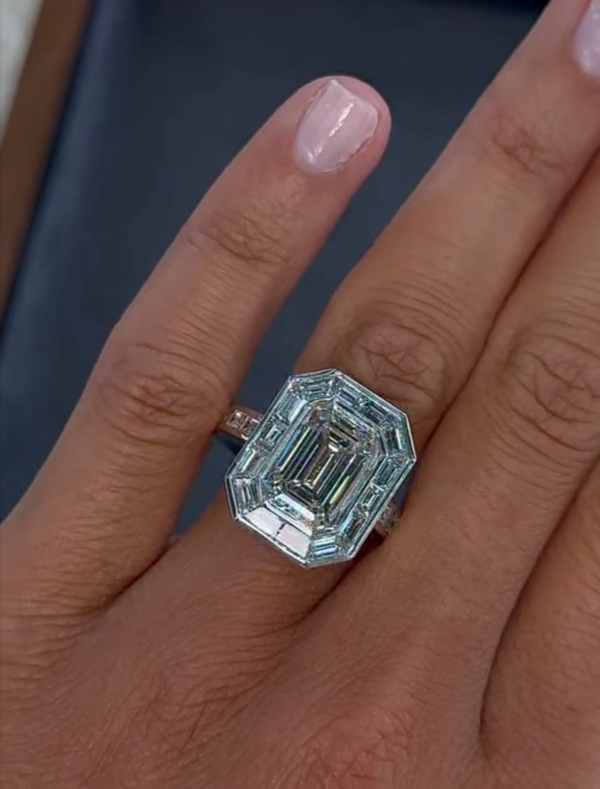 Emerald-cut diamond ring within a baguette halo