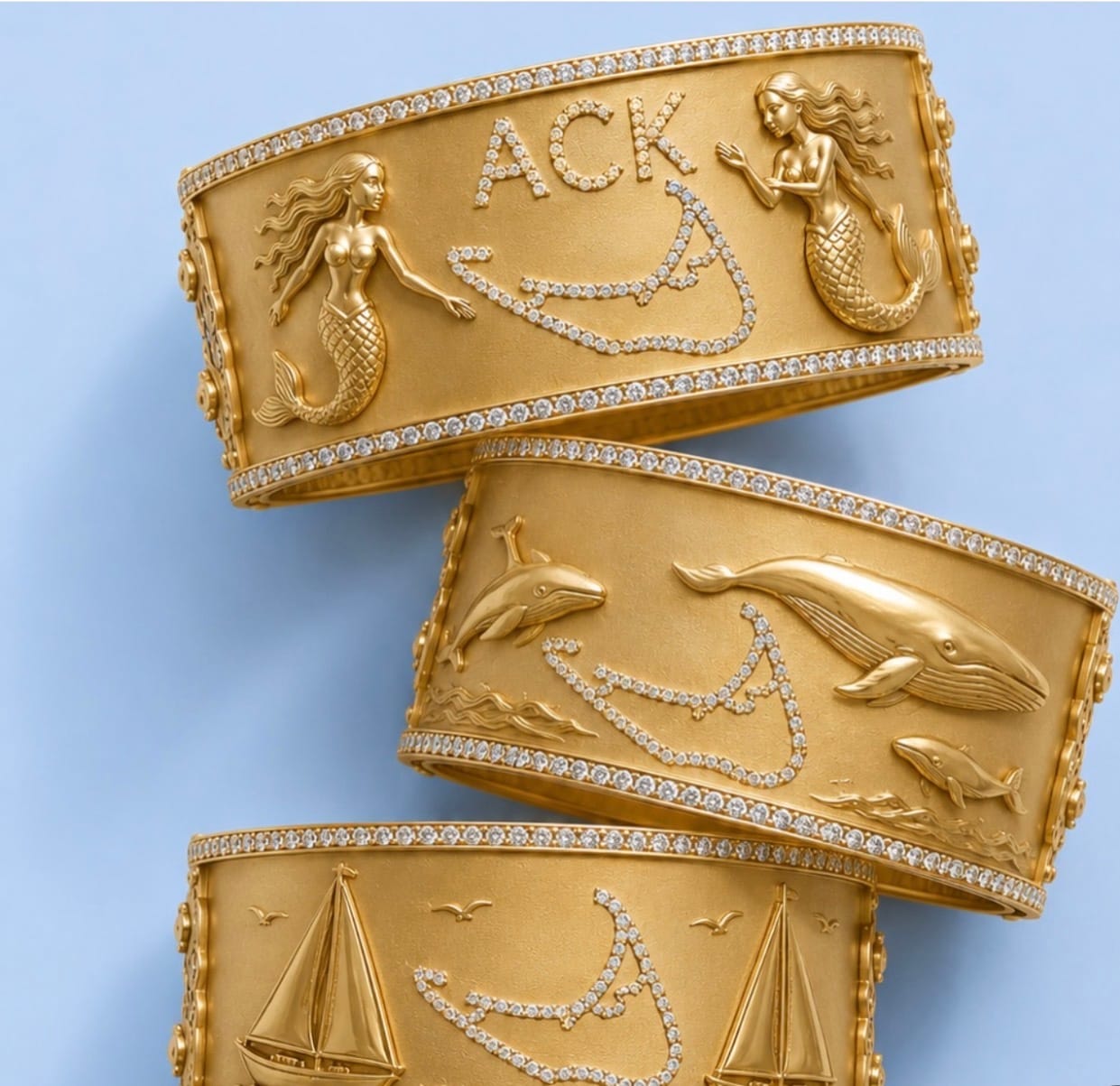 Hand-engraved 18k gold cuffs with pavé diamonds — mermaids, whales, and sailboats